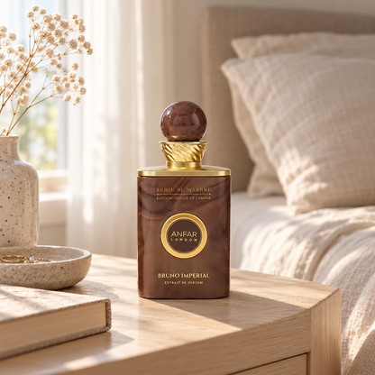 Anfar London Bruno Imperial perfume bottle on a pale wooden bedside table beside linen bedding in morning light