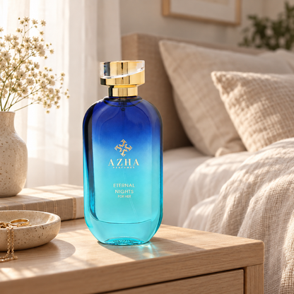 Azha Eternal Nights perfume bottle on a pale wooden bedside table beside linen bedding in morning light