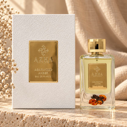 Azha Agarwood Amber Eau de Parfum 100 ml bottle with oud wood and amber resin inside, beside its white embossed box